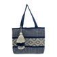 tote bag with a navy blue and white woven design, featuring a central diamond pattern and adorned with a layered tassel