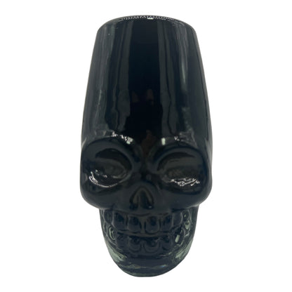 Black traditional Mexican shot glass shaped like a skull, made from handblown, eco-friendly recycled glass. It is sturdy, dishwasher safe, and holds approximately 2 fluid ounces