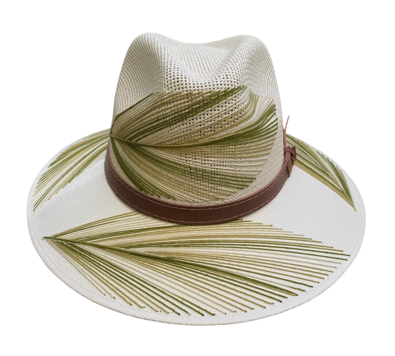 beige hat with green palm frond designs and a brown leather band.