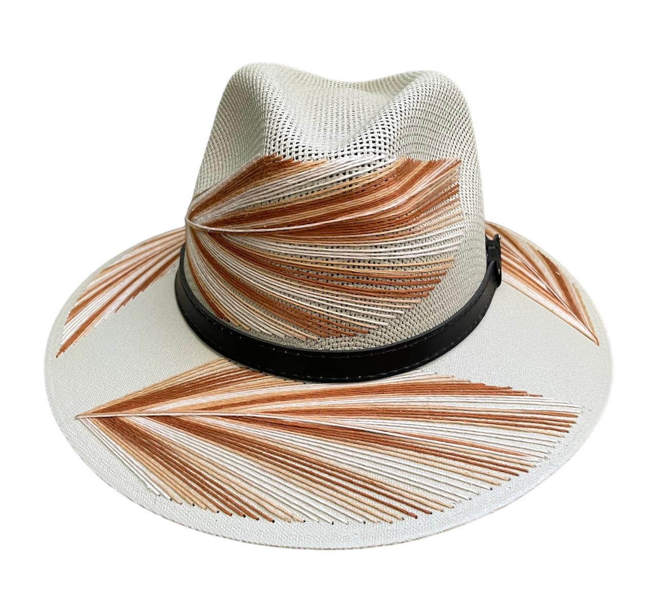 white hat with brown palm frond designs and a black leather band.