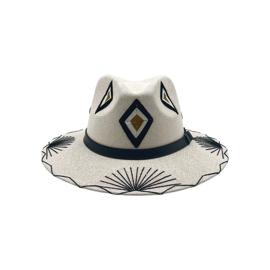 beige Fedora hat with unique hand-stitched tribal designs in black and gold. The hat features a wide brim and a black band, with diamond-shaped patterns on the crown.