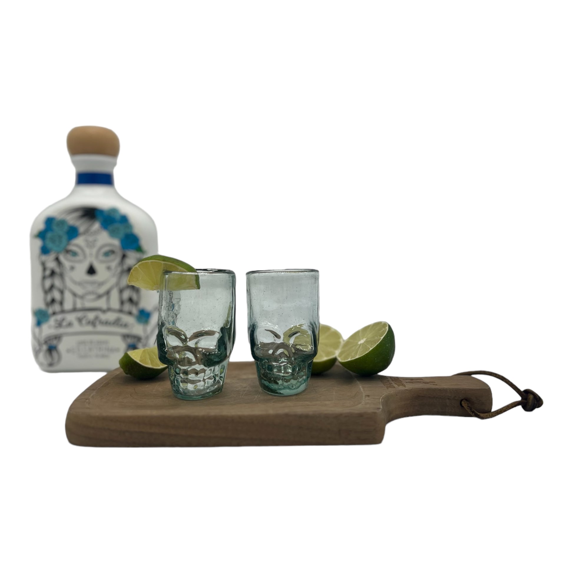 Mexican shot glass, shaped like a skull and crafted from eco-friendly recycled glass. The glass is translucent with a subtle greenish tint and holds approximately 2 fluid ounces.