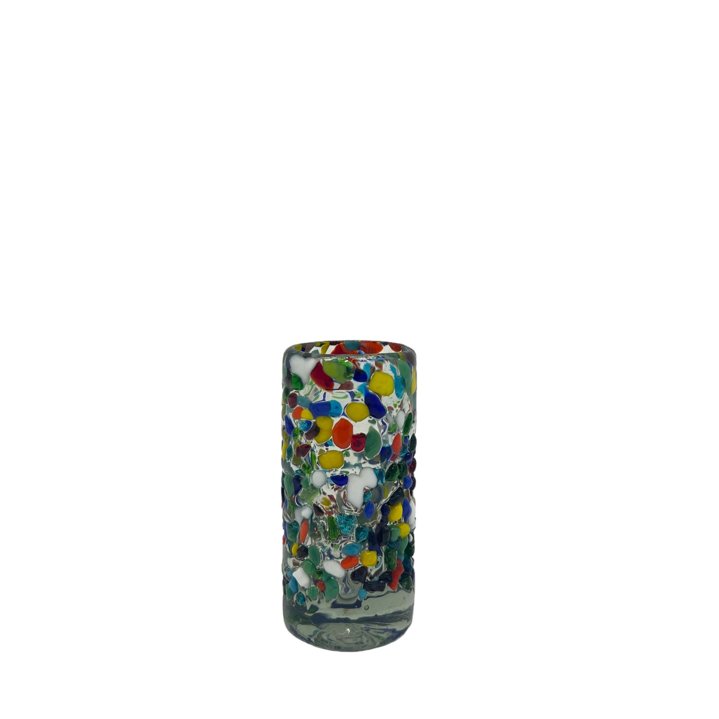 vibrant Mexican shot glass, handblown from eco-friendly recycled glass. It features a colorful mosaic of multicolored dots embedded throughout the glass, creating a festive and lively appearance. The glass is cylindrical and holds