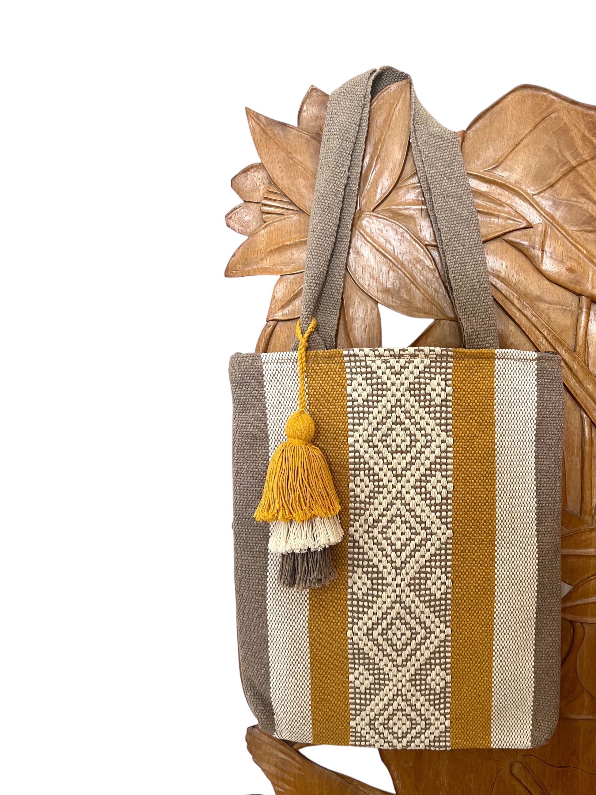 woven tote bag with vertical stripes in mustard yellow, beige, and brown, featuring a decorative tassel.