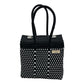 small black and white woven handbag with two handles and metal snap closures on the top.