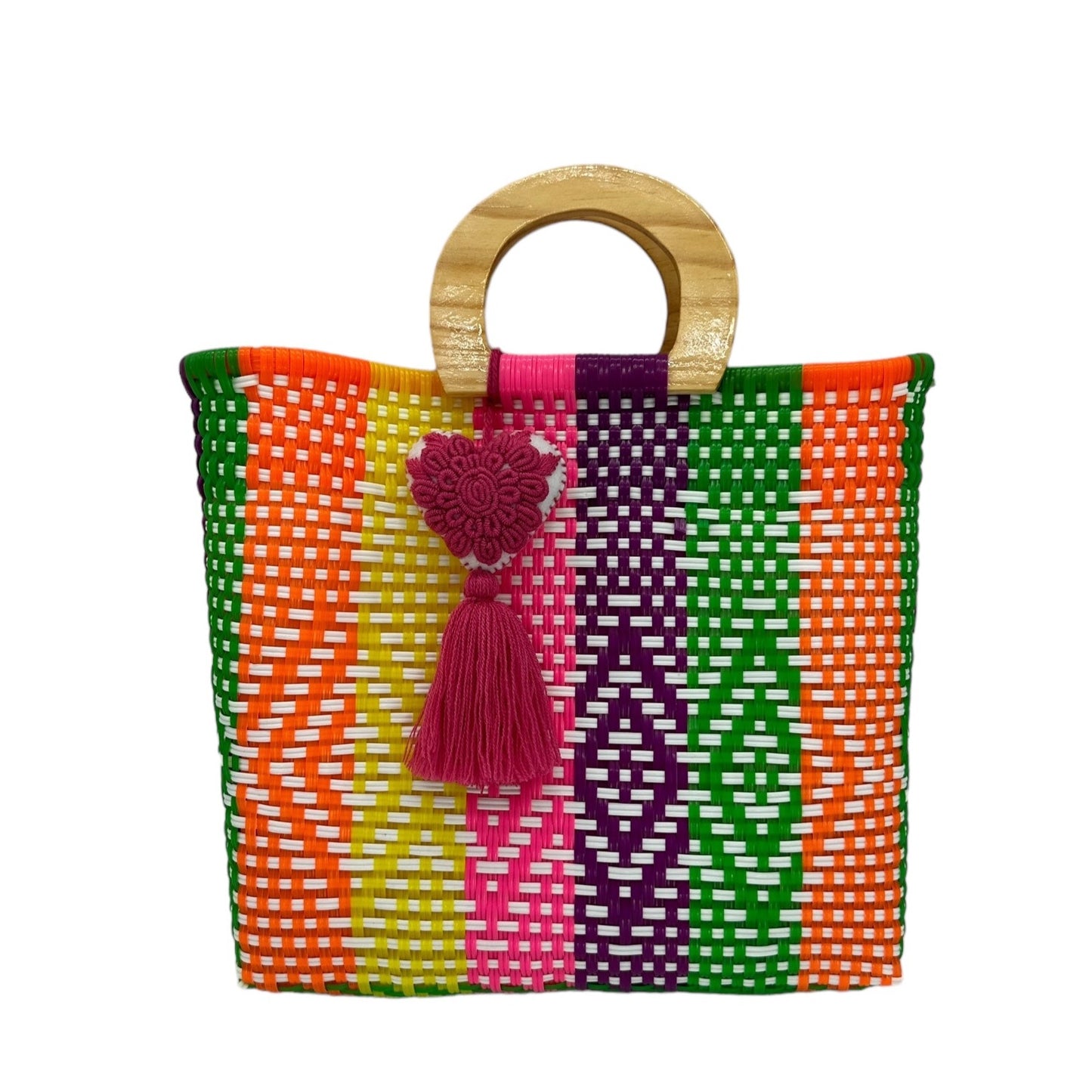 woven tote bag made of recycled plastic with a wooden circular handle. The bag features vertical stripes and geometric patterns in bright colors, including orange, green, yellow, pink, and purple. It is adorned with a  heart-shaped pompon