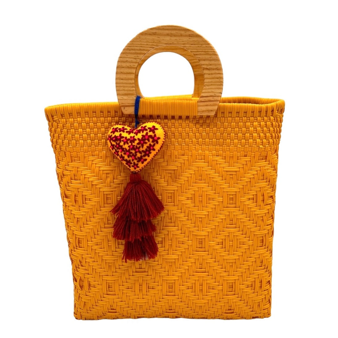 bright yellow woven tote bag made of recycled plastic with a wooden circular handle. The bag features a geometric pattern and is adorned with a  heart-shaped charm.