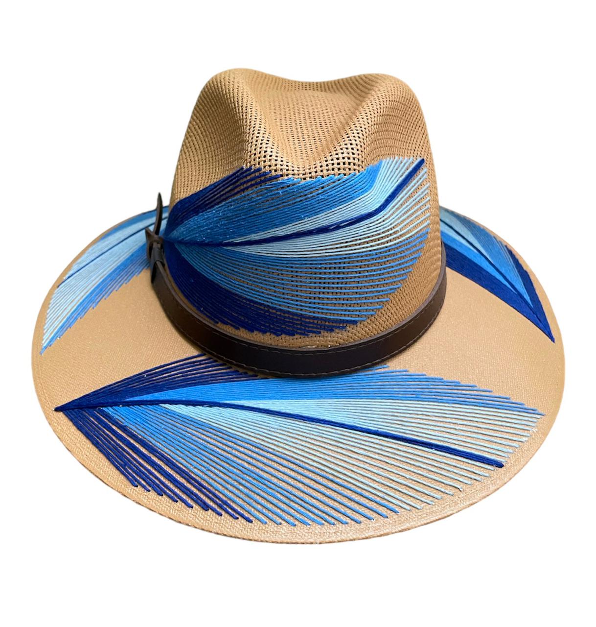 brown hat with blue and white palm frond designs and a brown leather band.