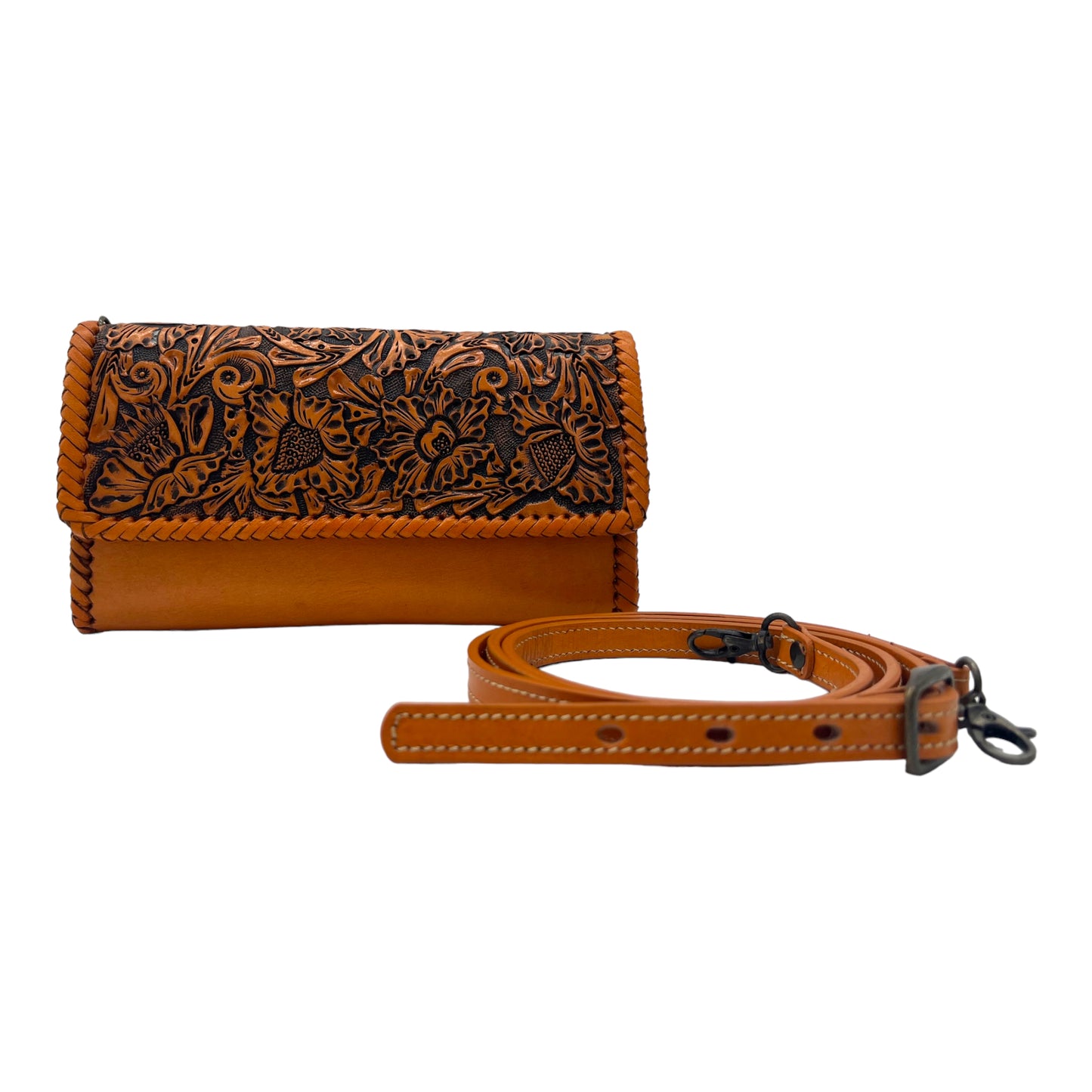 tan leather crossbody bag with intricate hand-carved floral designs on the front flap. It has a detachable and adjustable strap, also in tan leather.