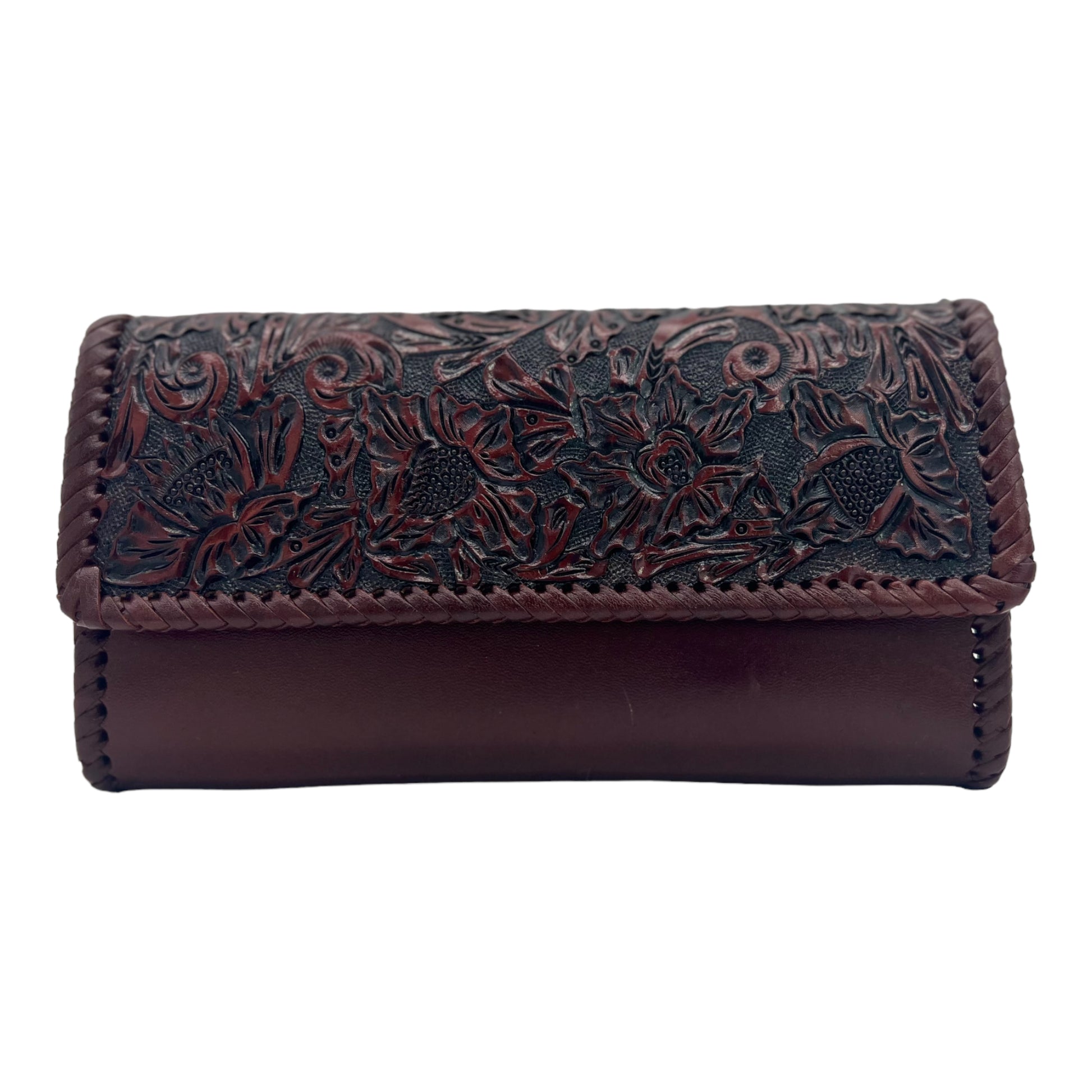 maroon crossbody bag with intricate black hand-carved floral patterns on the front flap. The bag features a sleek leather body and braided edges.