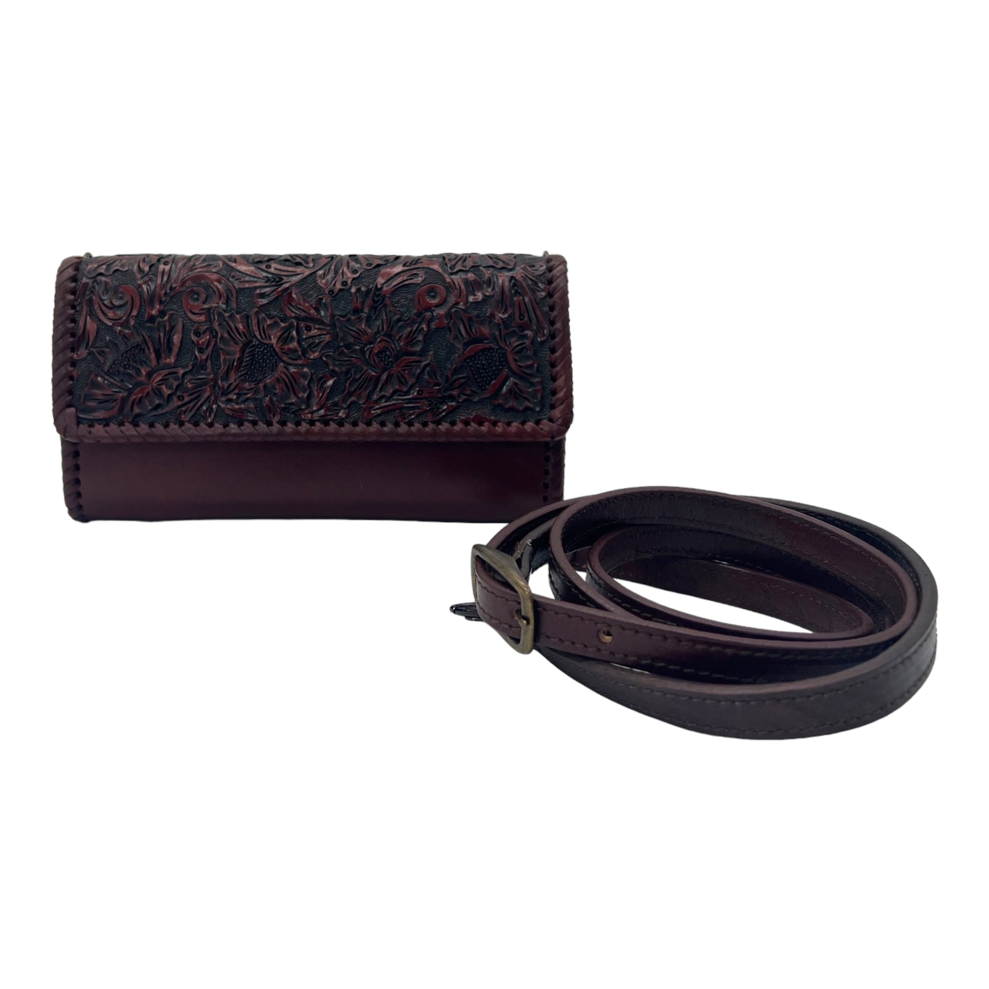 burgundy crossbody bag with intricate black hand-carved floral detailing on the front flap. The bag features a sleek design with an adjustable strap.