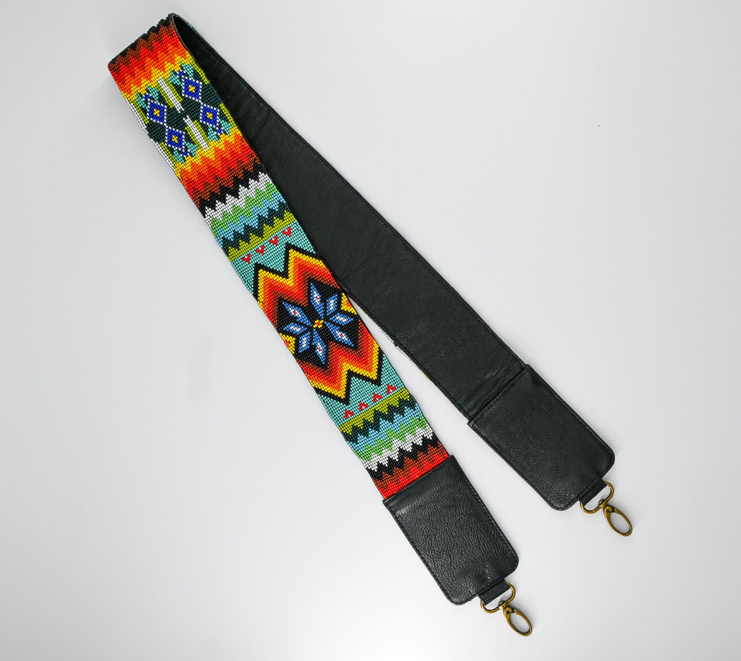Close-up of a colorful beaded strap with intricate geometric and floral patterns in vibrant hues, showcasing detailed craftsmanship.