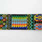 Close-up view of a colorful beaded strap with intricate traditional patterns, showcasing vibrant geometric designs and detailed craftsmanship.