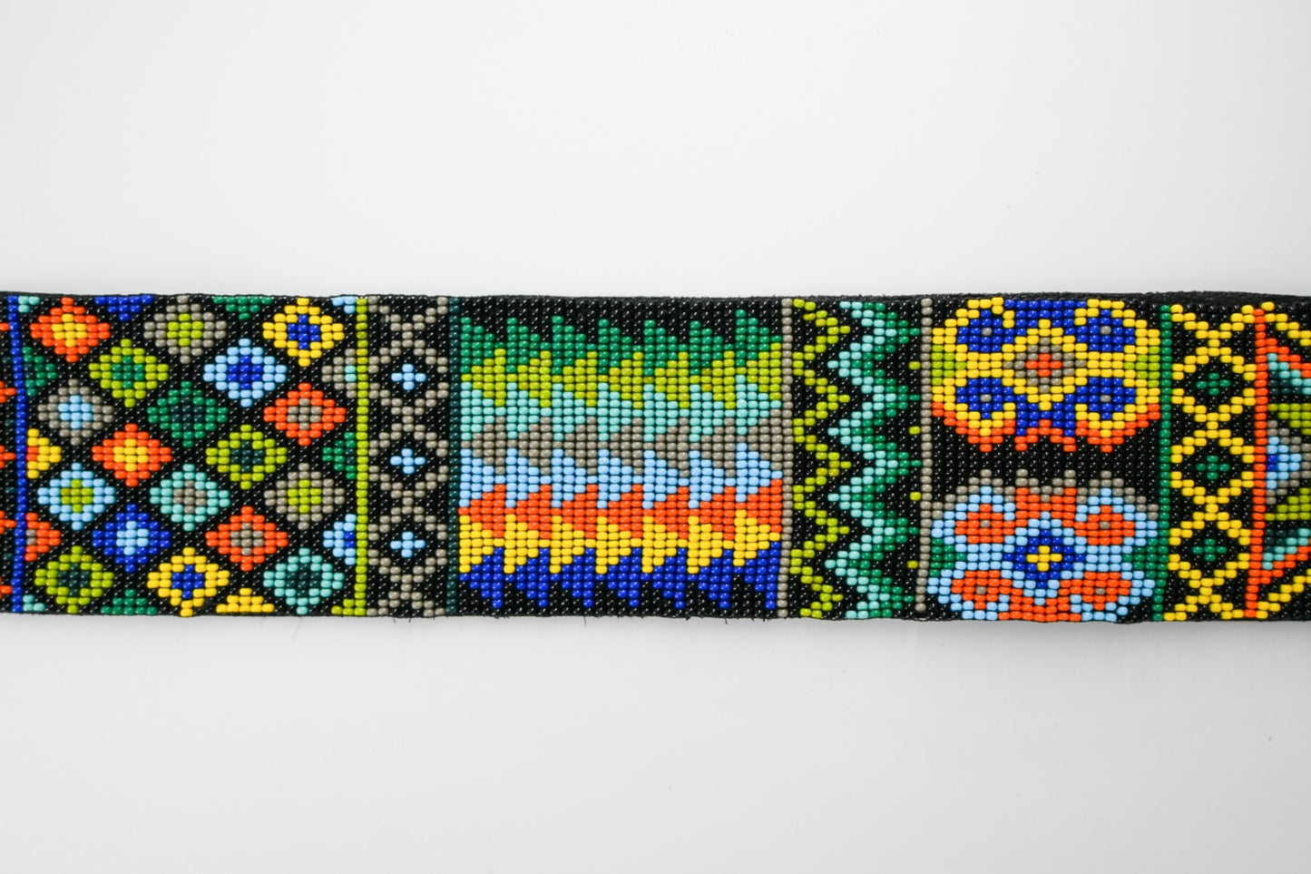 Close-up view of a colorful beaded strap with intricate traditional patterns, showcasing vibrant geometric designs and detailed craftsmanship.