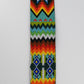Close-up view of a colorful beaded strap with intricate traditional patterns, showcasing vibrant geometric designs and detailed craftsmanship.