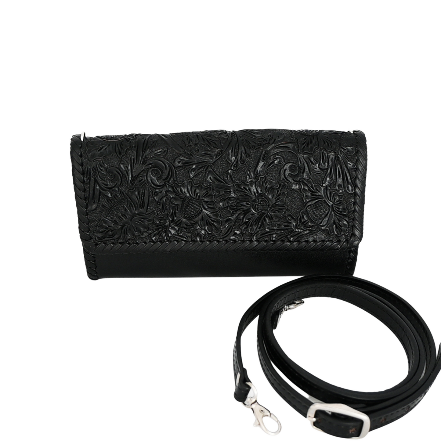 Solid black crossbody bag with detailed hand carving on the front flap, a black leather body, an adjustable black shoulder strap, and magnetic snap closures.