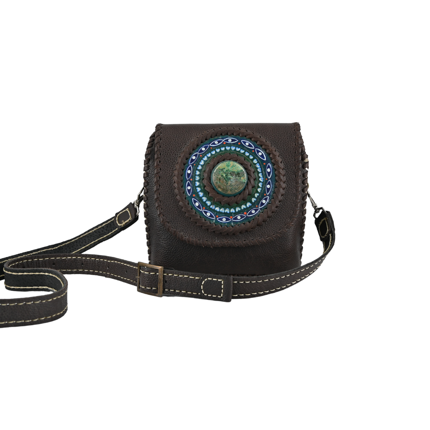 dark brown small crossbody bag with a circular medallion on the front featuring blue and green details. It has an adjustable shoulder strap and visible white stitching along the strap edges.