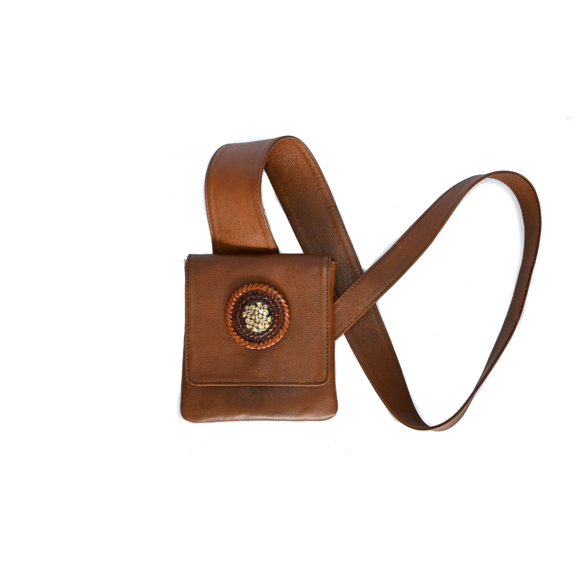 brown leather crossbody bag with an ergonomic strap and a circular medallion on the front flap.