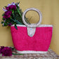 woven handbag with a fuchsia body and a circular handle