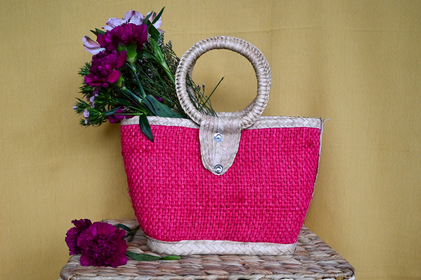 woven handbag with a fuchsia body and a circular handle