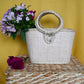 woven handbag with a turquoise body and a circular handle