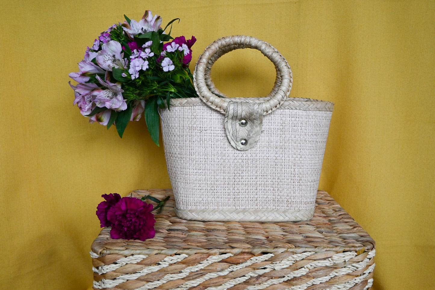 woven handbag with a turquoise body and a circular handle