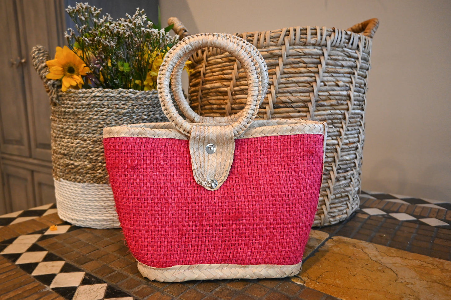 shows a woven handbag with a red body and a circular handle