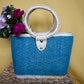 woven handbag with a turquoise body and a circular handle