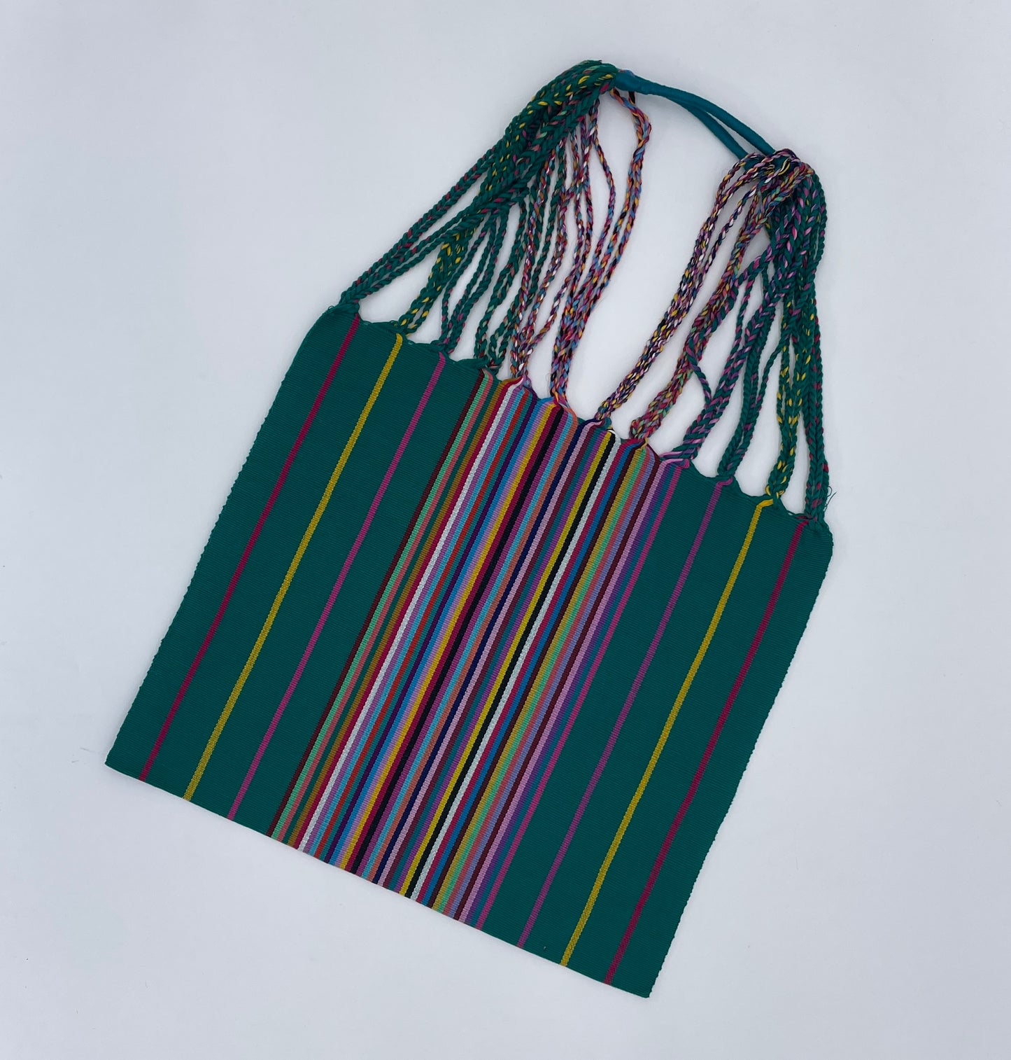 handwoven tote bag featuring vibrant, multicolored stripes on a dark green background with intertwined straps.