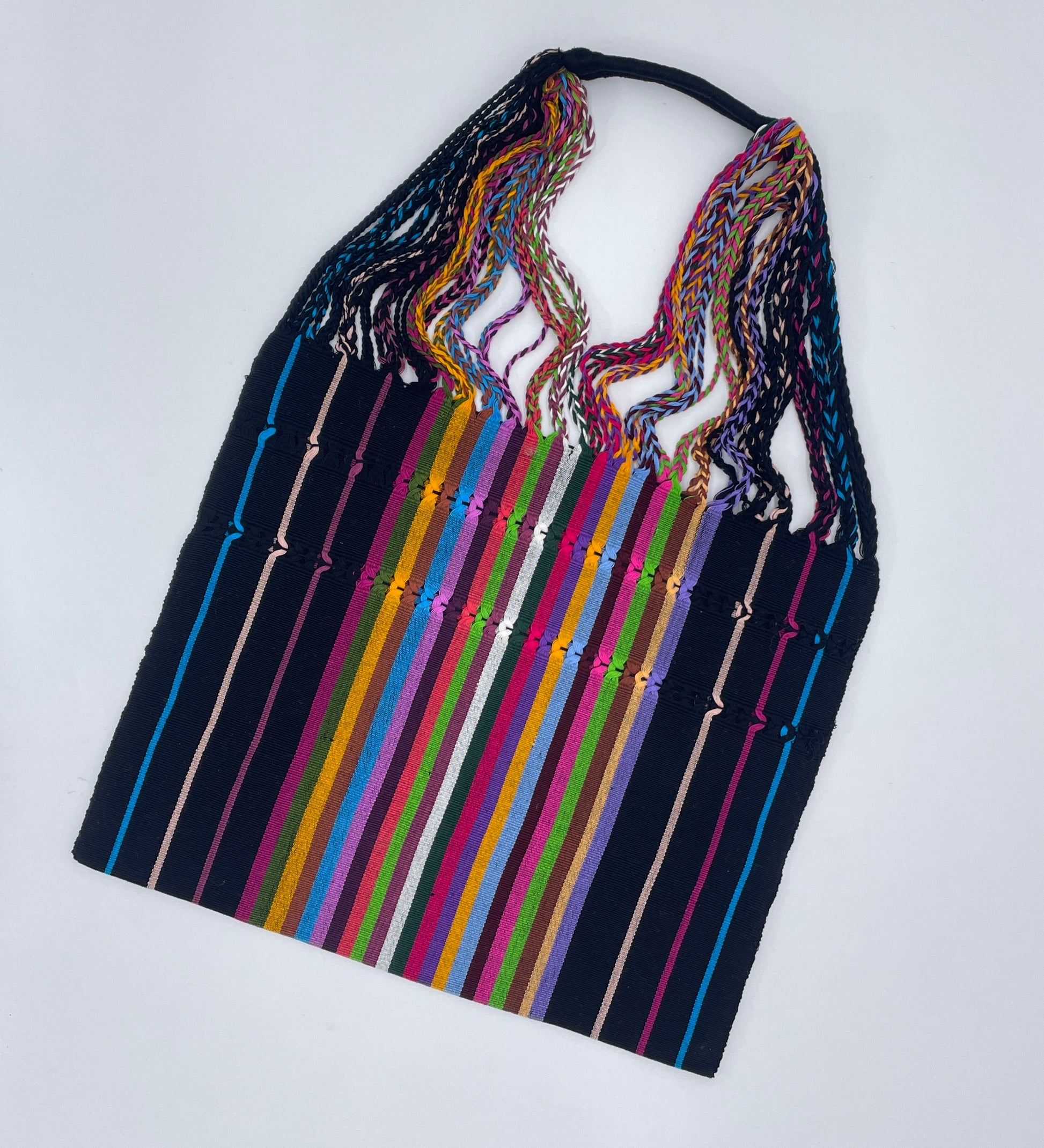 handwoven tote bag featuring vibrant, multicolored stripes on a dark background with braided, colorful straps.