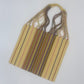 handwoven tote featuring yellow with pink, brown, and blue stripes, and a central section with multicolored stripes. The straps are braided with various colors.