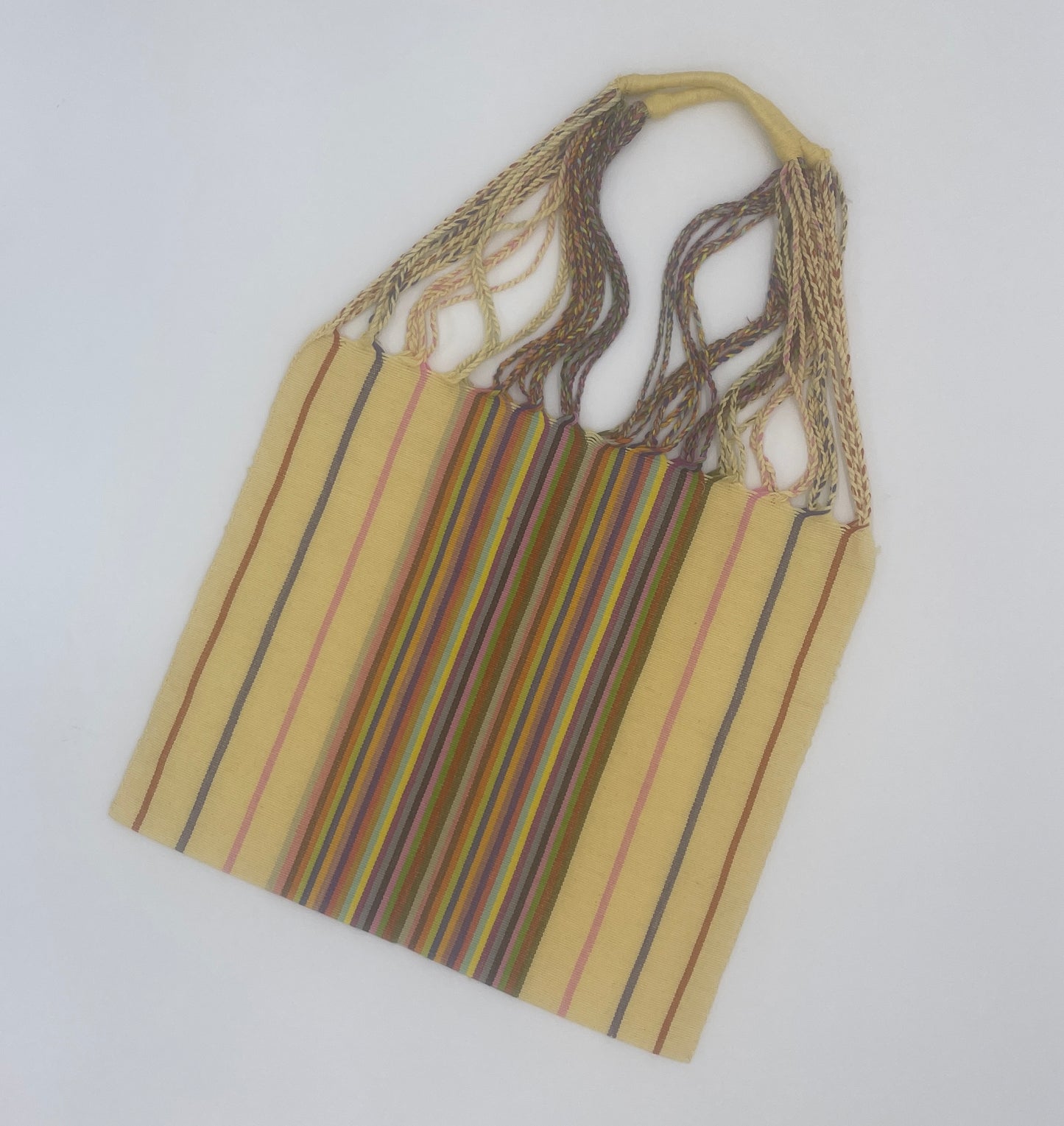 handwoven tote featuring yellow with pink, brown, and blue stripes, and a central section with multicolored stripes. The straps are braided with various colors.