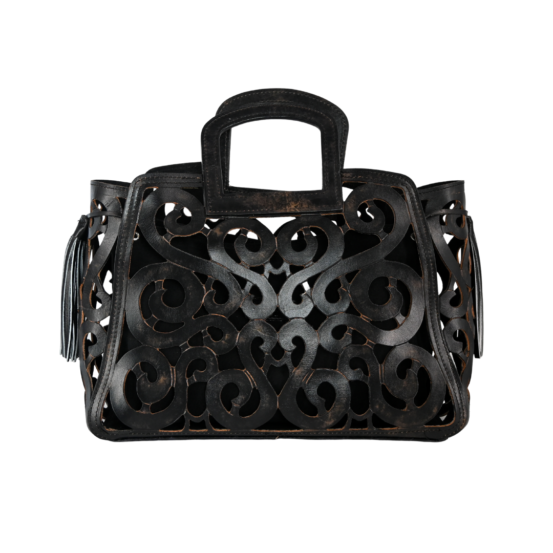 black leather tote bag with an intricate cut-out design and tassel accents on both sides.