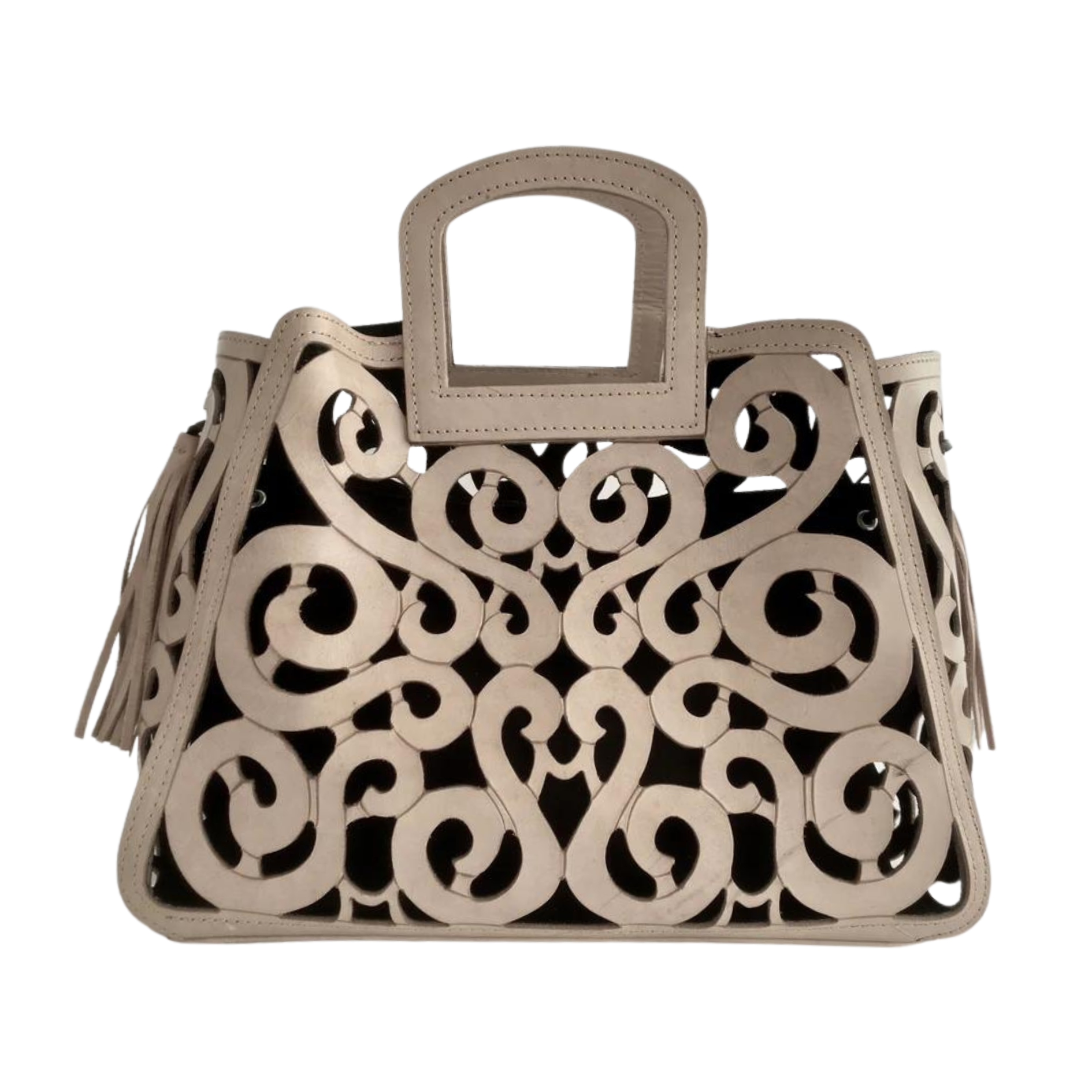 Nude leather tote with intricate scroll patterns and tassels on the sides. It has a cut-out handle and a structured, decorative design