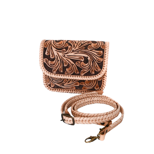 light brown crossbody bag with intricate hand-tooled floral patterns on the front flap and body. The bag features braided edges and a matching adjustable strap.