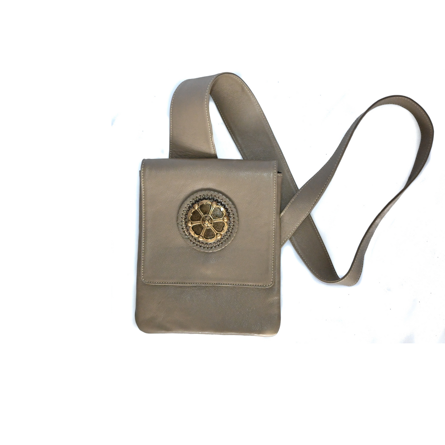 taupe leather crossbody bag with an ergonomic strap and a decorative circular medallion on the front flap.