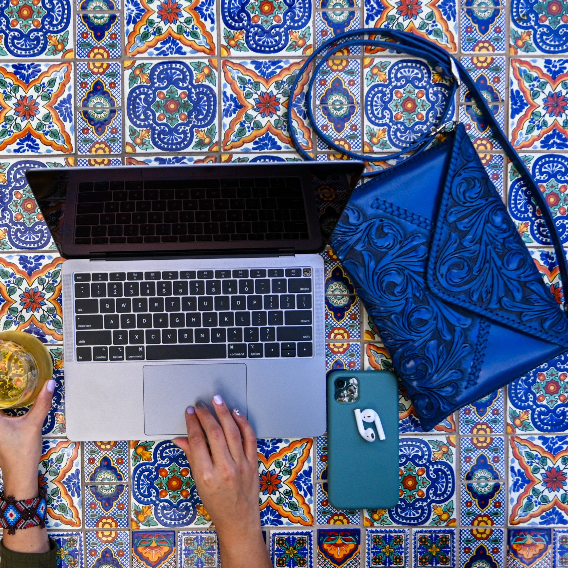 vibrant blue crossbody bag with an embossed floral pattern