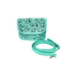 turquoise crossbody bag with intricate hand-tooled floral patterns on the front flap and body. The bag features braided edges and a matching adjustable strap.