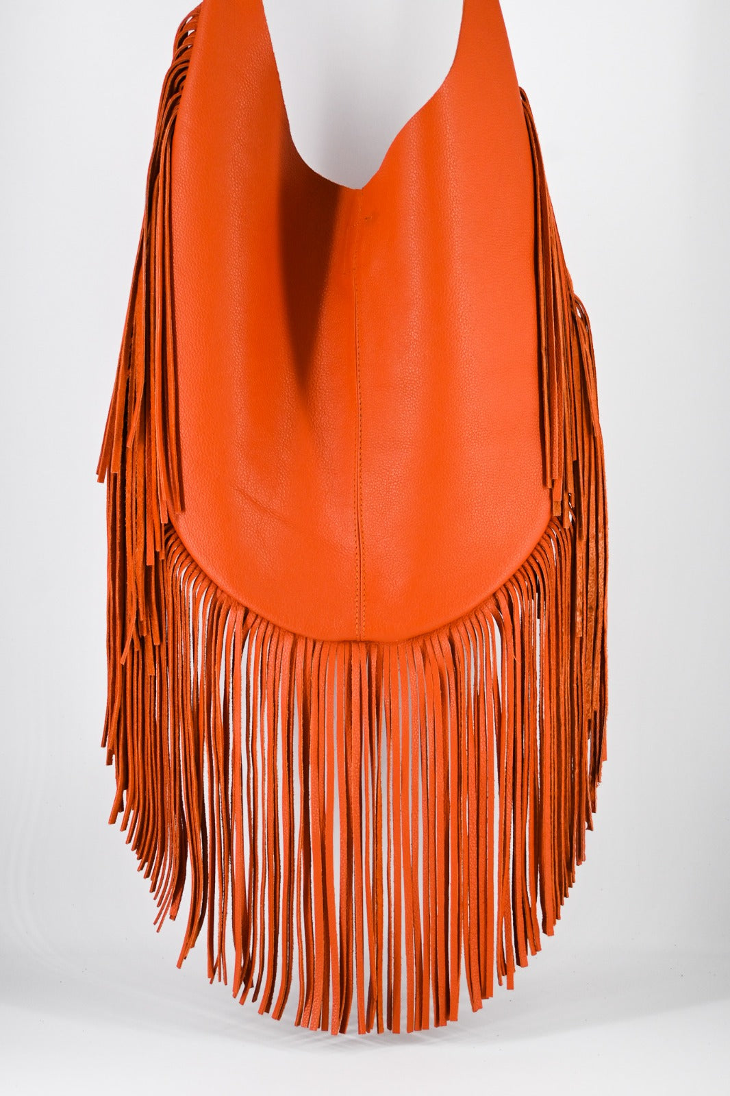 bright orange leather bag with long, flowing fringe details along the sides and bottom.