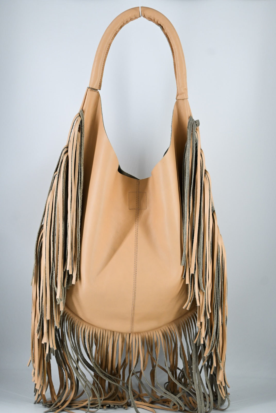 tan leather bag with long fringe details along the sides and bottom, featuring a padded wrapped shoulder strap.