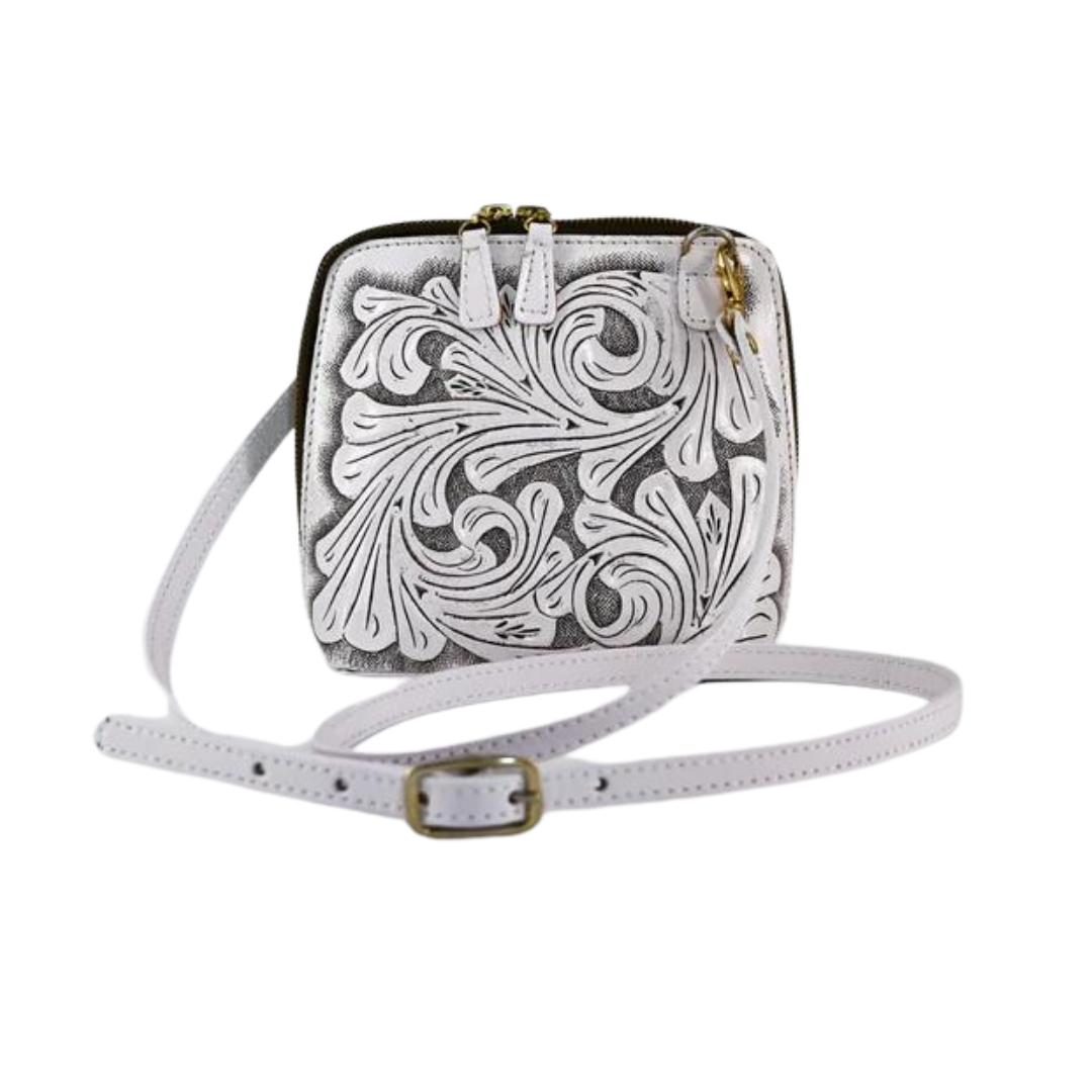 white shoulder bag with intricate hand-carved floral details, featuring a zip-around closure and an adjustable strap.