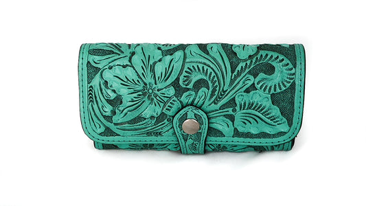 teal leather, intricately embossed with a floral pattern, and secured with a snap closure.