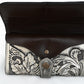two-tone wallet with a black leather flap and a silver-gray body, intricately embossed with a floral pattern. The wallet is secured with a snap closure.