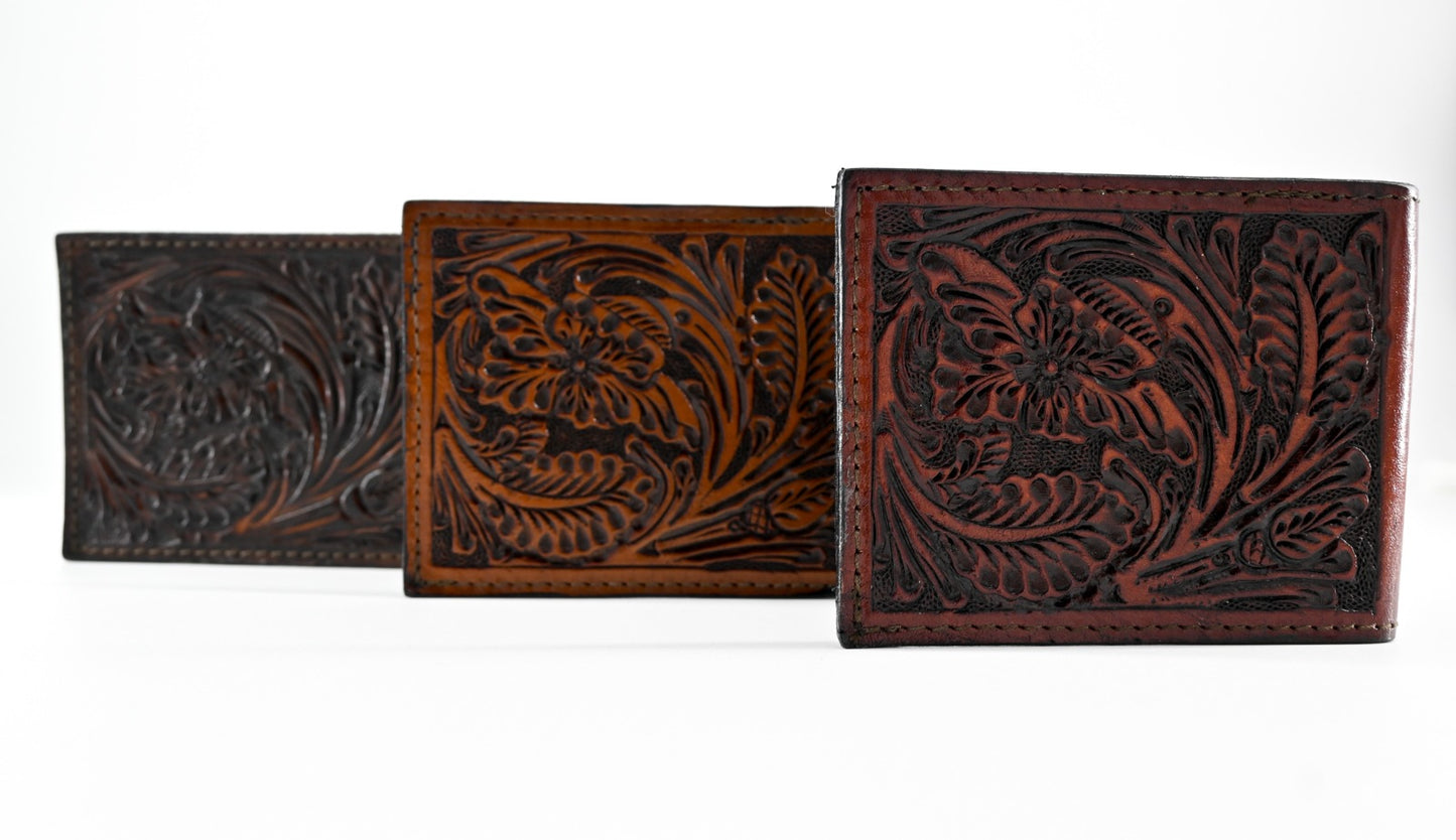 Three leather wallets with intricate floral carvings in a row, featuring black, caramel, and burgundy colors.