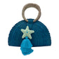 Blue woven palm handbag with a circular handle wrapped in light material. The bag features a decorative star and a tassel on the front.