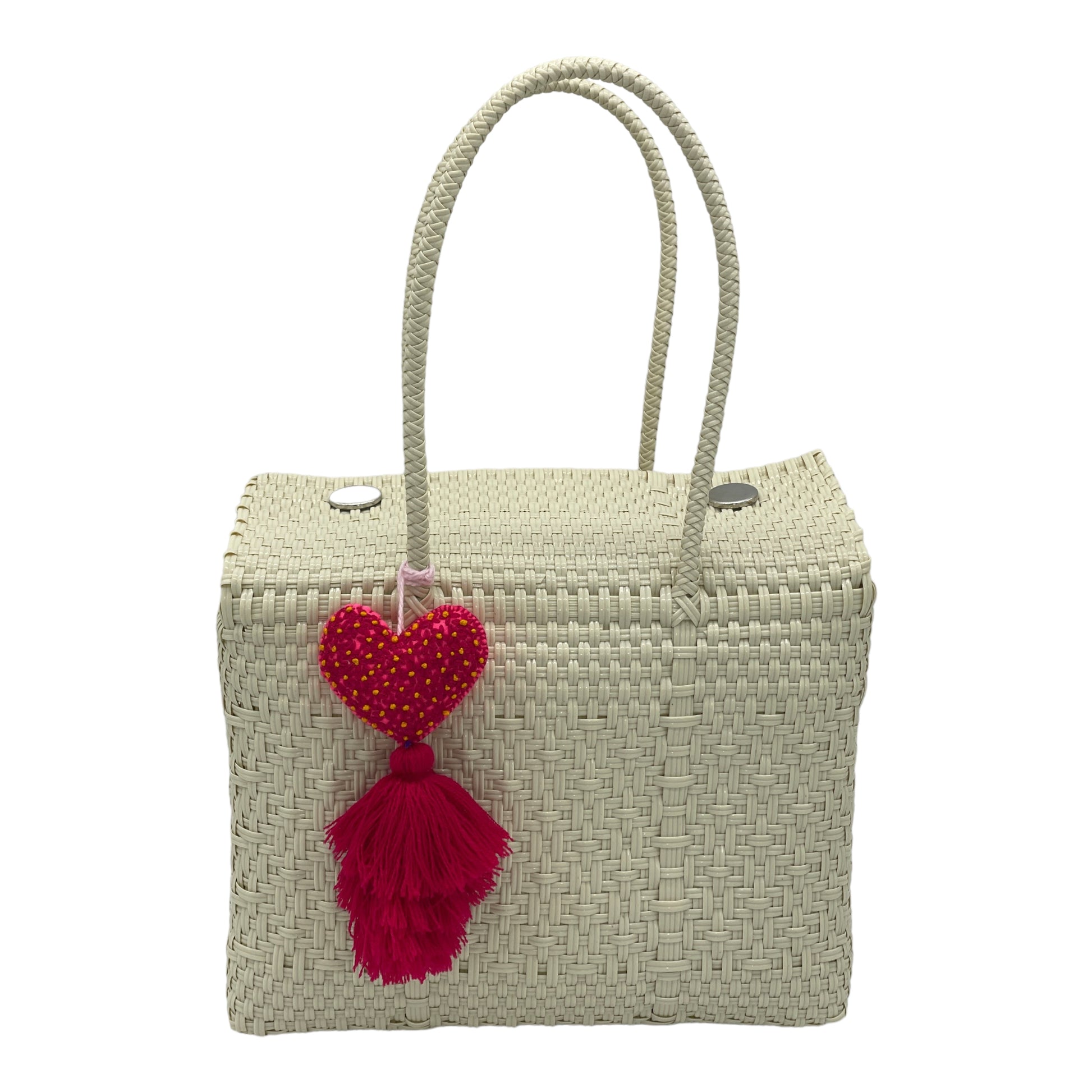 Solid white woven handbag featuring a decorative tassel with a heart.