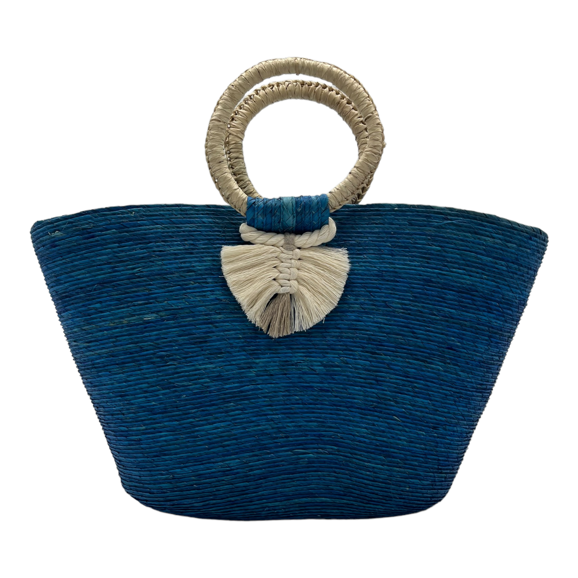 large blue woven tote bag made of palm fibers with a circular handle. The bag features a decorative tassel.