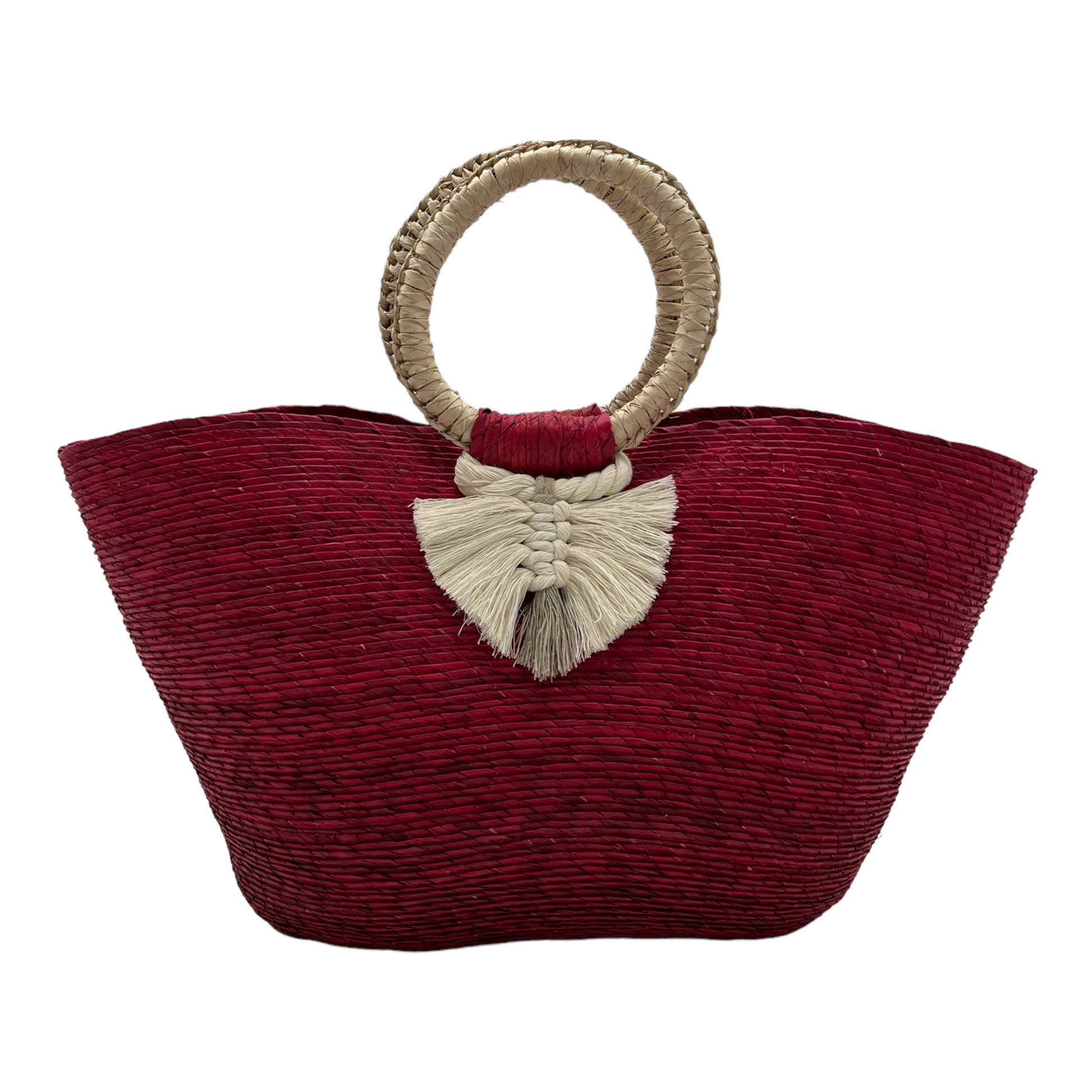 large red woven tote bag made of palm fibers with a circular handle. The bag features a decorative tassel.