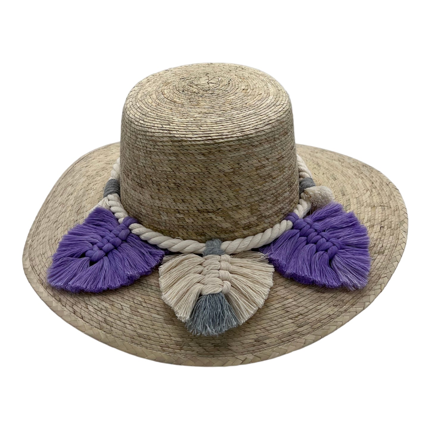 natural straw hat with a wide brim, adorned with a thick braided band and large tassels in cream and purple around the crown.