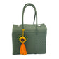 Solid green woven handbag featuring a decorative  tassel with a sunflower heart
